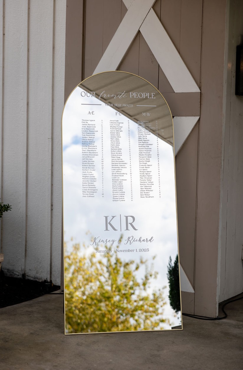 Mirrored wedding seating chart at a venue entrance