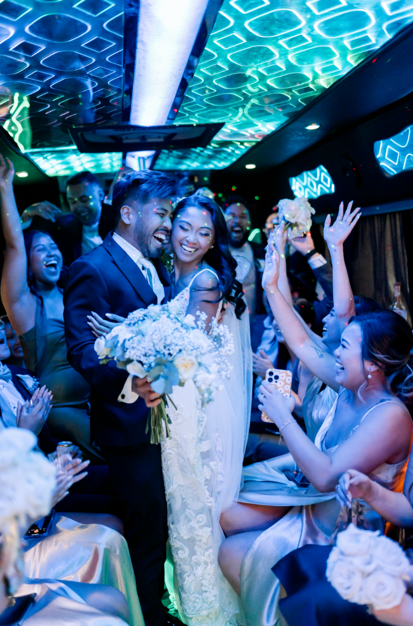 Newlyweds celebrating with guests in a wedding limo
