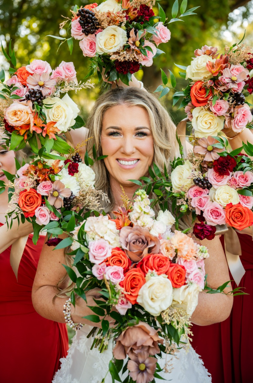 Bride framed by colorful floral bouquets